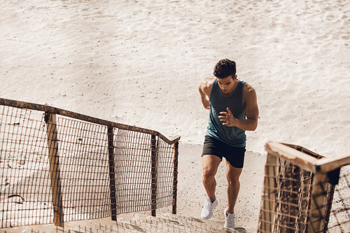 Man running up the staircase on beach