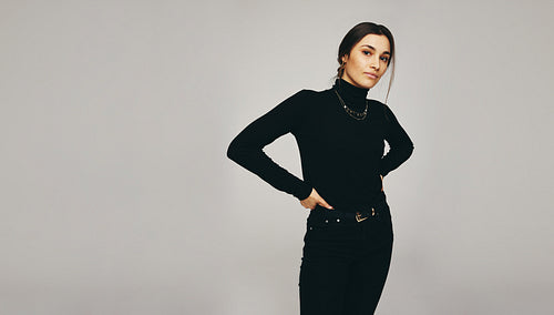 Confident young woman looking at the camera in a studio