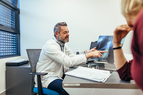 Doctor showing x-rays to patient in medical office