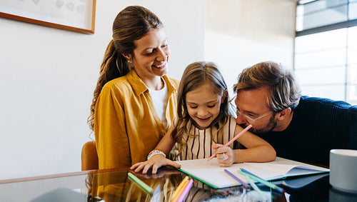Family moment: mom and dad with daughter drawing
