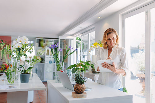 Florist making notes on clipboard