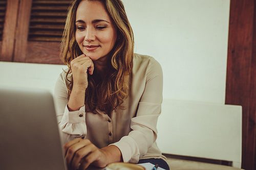 Woman working on laptop at coffee shop