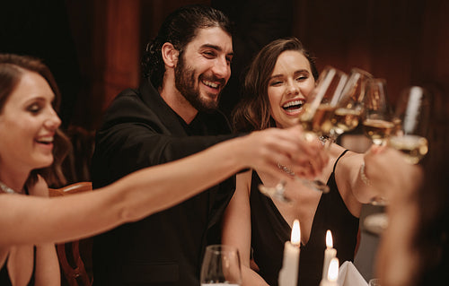 Multi-ethnic people celebrating dinner party with drinks