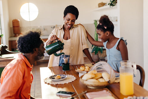 Brazilian family breakfast: Mom pours strained coffee at the breakfast table