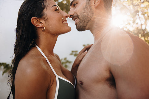 Couple touching their noses under an outdoor shower
