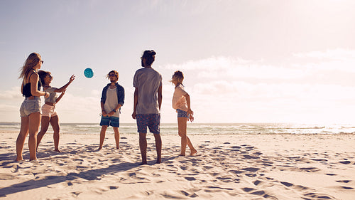 Group of friends playing with ball at beach