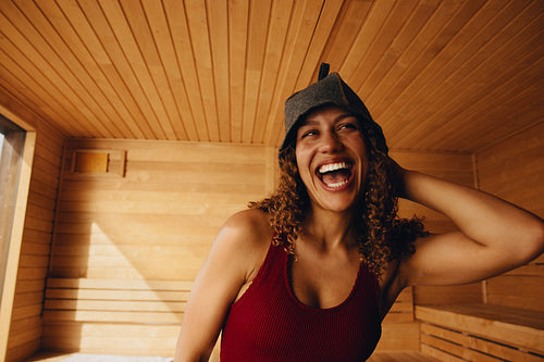 Woman laughing in sauna for wellness relaxation and spa self care portrait