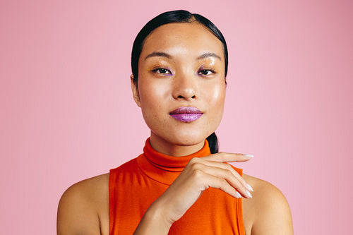 Youthful woman with bold lip primer looking at the camera in a studio