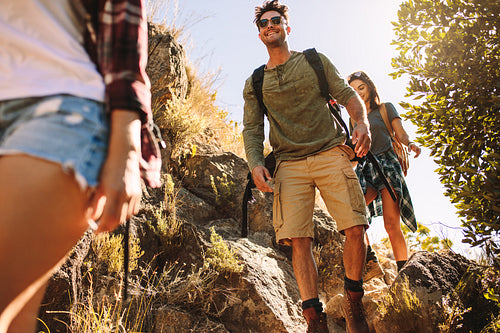 Friends hiking on rocky mountain trail