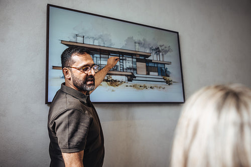 Male architect presenting a modern house project design in an office discussion
