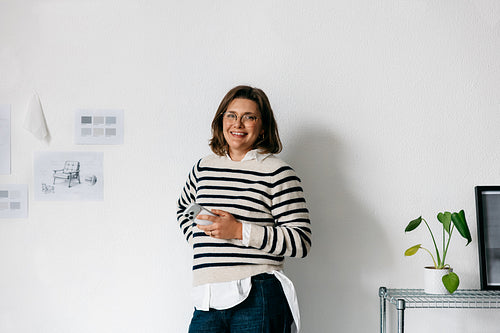 The woman manages business communication on her smartphone in a design studio