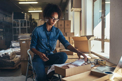 Woman packaging box for delivery