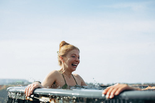 Young woman smiling in a cold plunge during Nordic wellness ritual