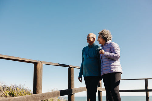 Happy senior couple looking at a refreshing view at the beach