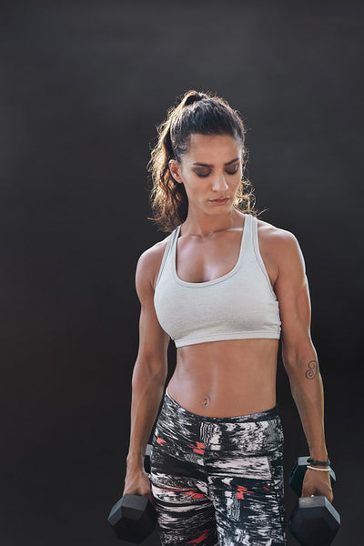 Fitness model exercising with dumbbells