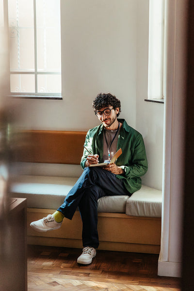 Professional man writing notes while sitting in a stylish and modern co-working space