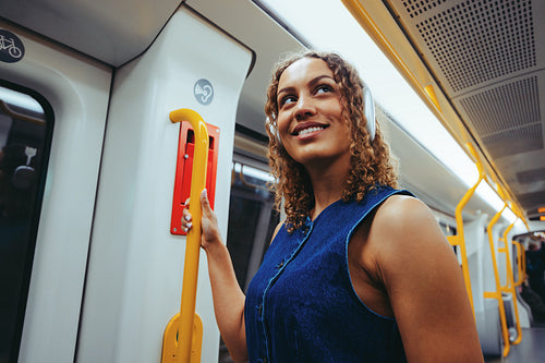 Woman on a train holding a handrail during commute
