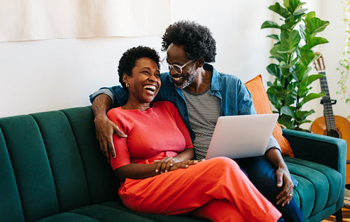 Happy couple laughing and bonding at home