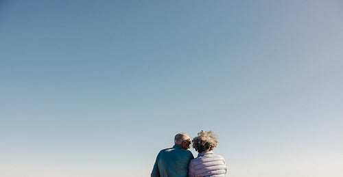 Rearview of a senior couple getting a refreshing view at the beach