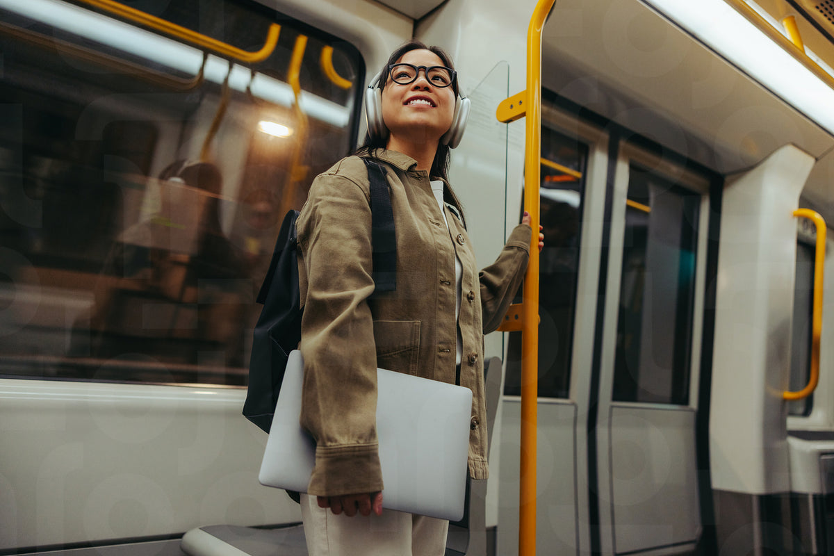 Commuter woman on train smiling with laptop – Jacob Lund Photography ...