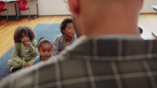 Male teacher teaching an elementary school class using a digital tablet
