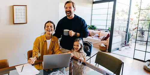 Family joy at home with laptop and coffee