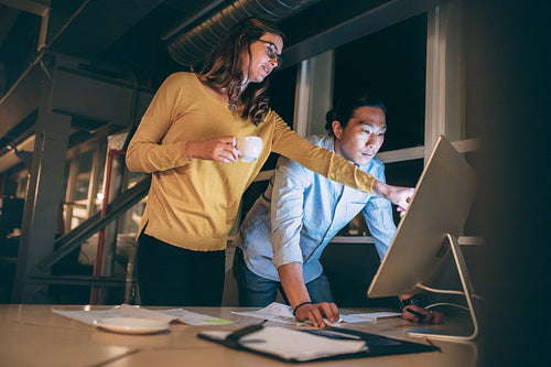 Business man and woman working late in the night at office