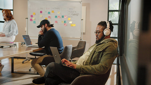 Male software developer working in a boardroom with his colleagues