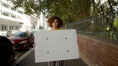 Portrait of a woman holding empty billboard on sidewalk