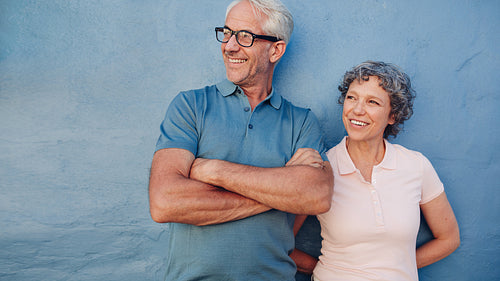 Smiling mature couple standing together and looking away