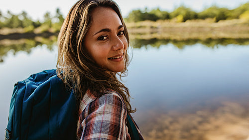Female camper standing by the lake