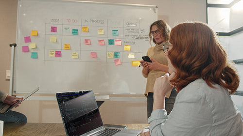 Business women having a discussion with their scrum master in an office