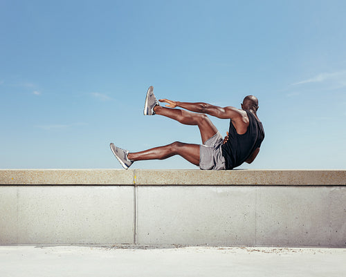 Strong young man exercising outdoors