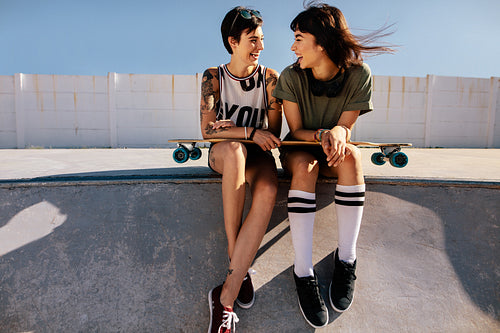 Female friends in skate park laughing and having fun