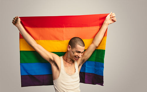 Gay man smiling with a lgbt flag