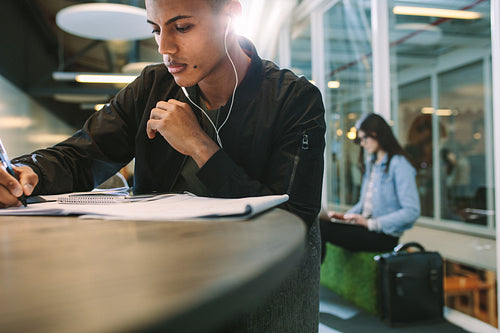Student at the library listen to music and making notes