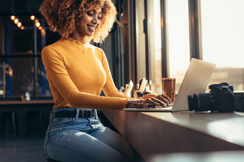 Woman working on laptop sitting at a restaurant