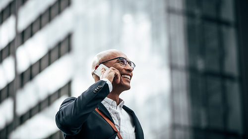 Business executive talking on mobile phone outdoors