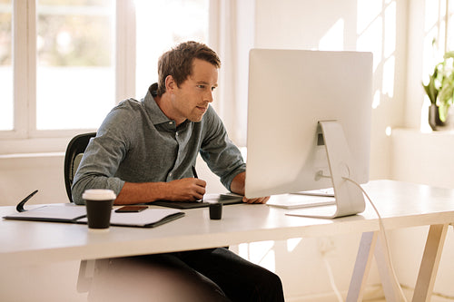 Man using a digitizer to write text in computer