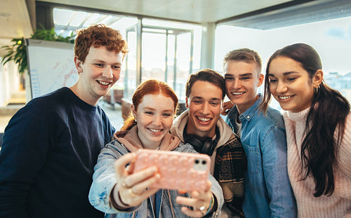 Girl taking selfie with friends in university