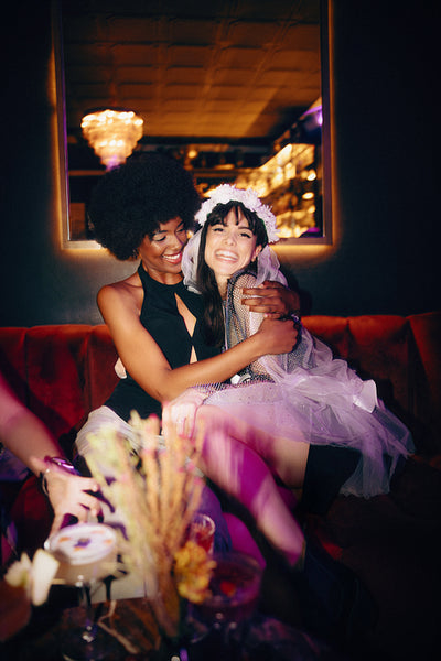 Two friends celebrating during a joyful bachelorette party evening in a lounge