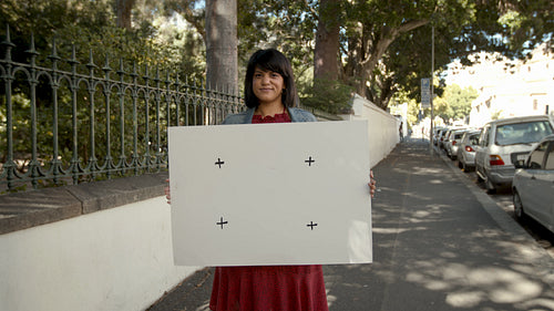 Woman standing with a blank billboard on sidewalk