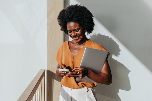 Mature woman using a smartphone on a workplace balcony during the day