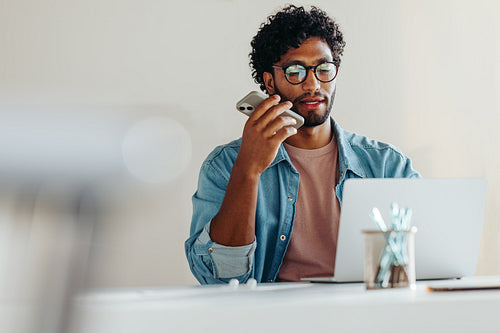 Young businessman engaged in a phone call at work