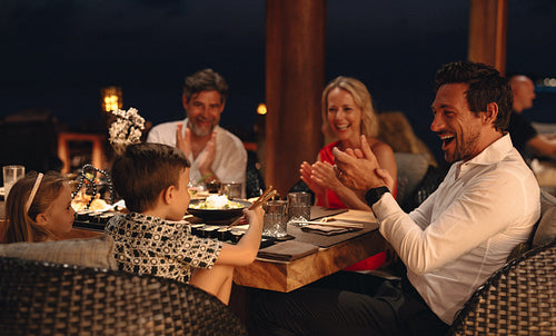 Family enjoying a joyful dinner together at a luxury restaurant setting