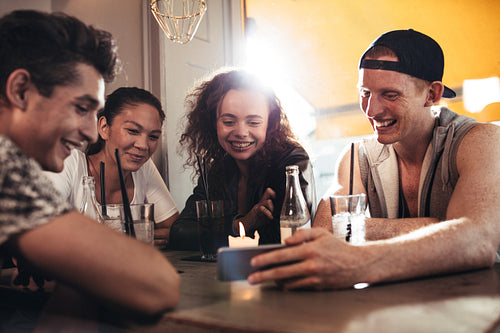 Cheerful young friends looking at smart phone