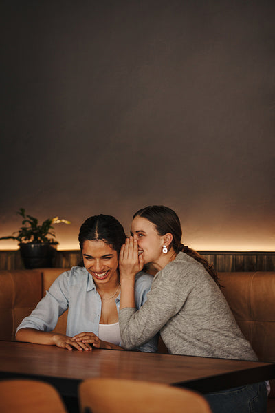 Woman sharing a secret with friend