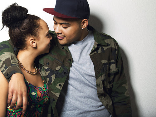 Affectionate cool young couple on grey background