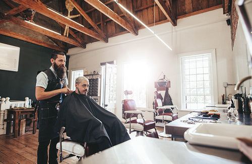 Young man getting haircut at barber shop