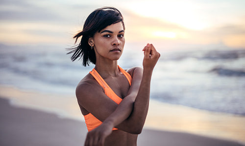 Woman doing warm up exercise at the beach